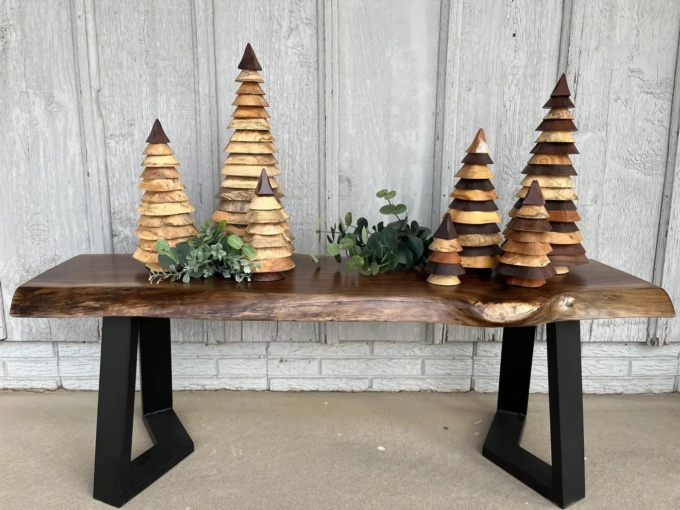 Handcrafted wooden trees resting on a solid hardwood bench