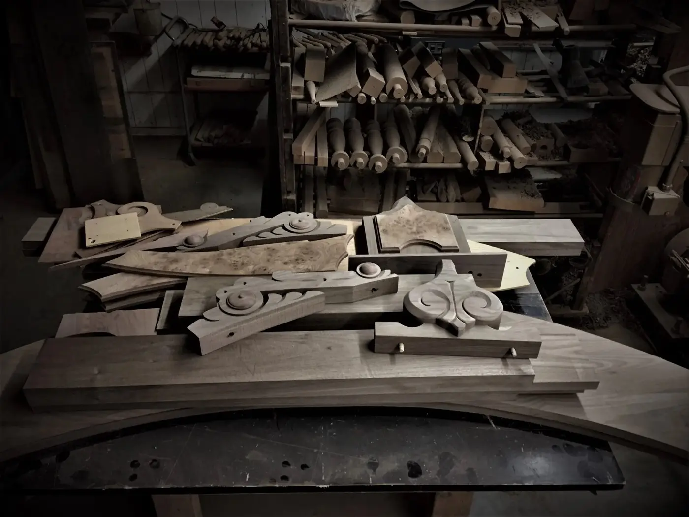Hand-carved wooden pieces arranged on the workshop bench